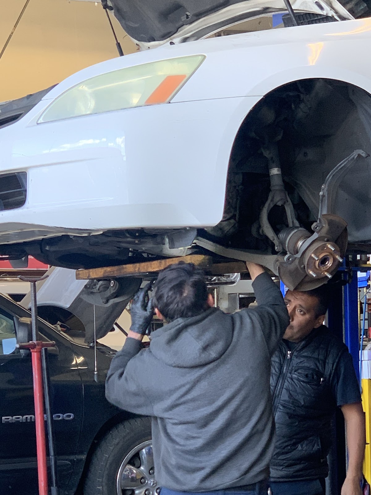 Technicians working under a car on the lift